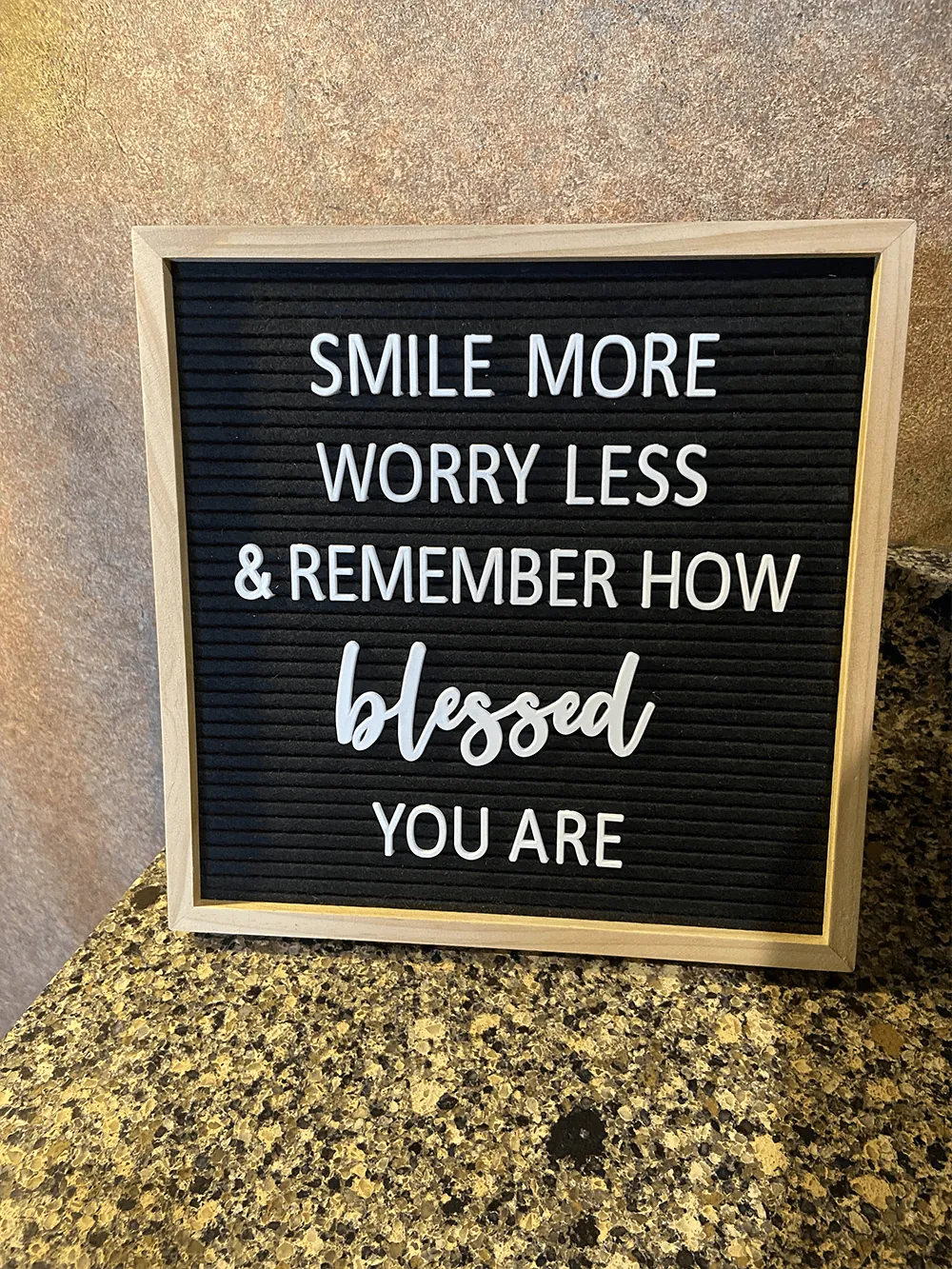 A letter board in the office reading Smile more, worry less and remember how blessed you are