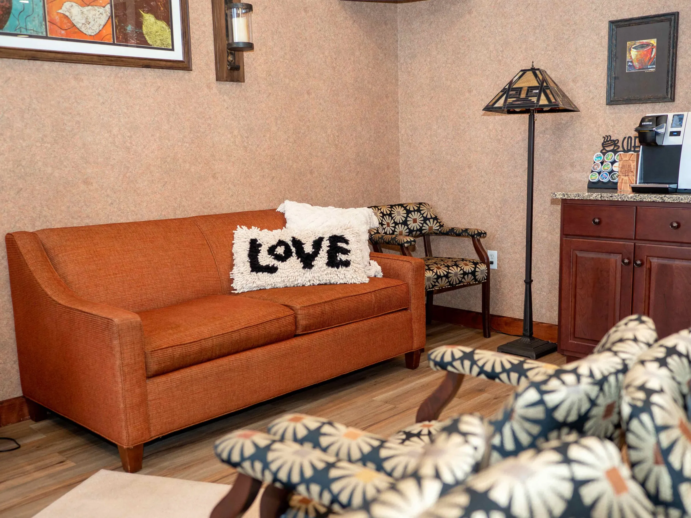 The patient lounge at Summit Pointe Dental, with an orange sofa and a Love pillow